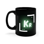 A black coffee mug with a white and green logo on the side. The logo features the chemical symbol for krypton (Kr)