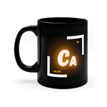 A black coffee mug with a white and orange logo on the side. The logo features the chemical symbol for calcium (Ca)